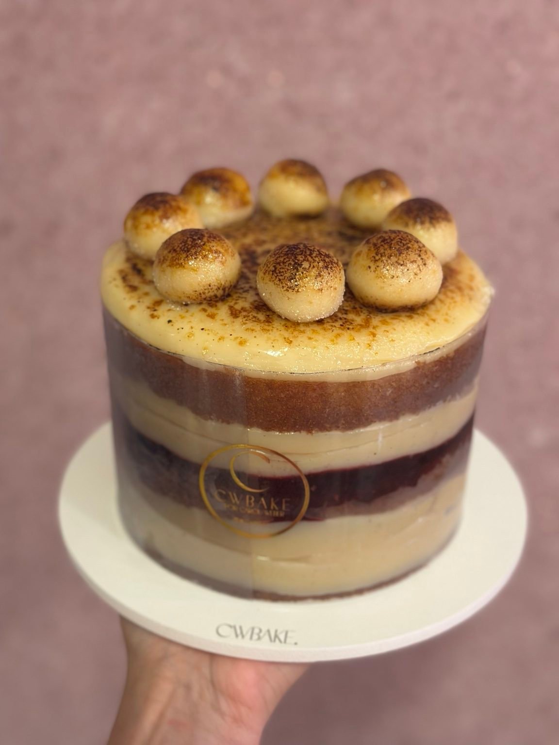 Bolo naked no acetato, com camadas aparentes e brigadeiros de brulée caramelizados no topo