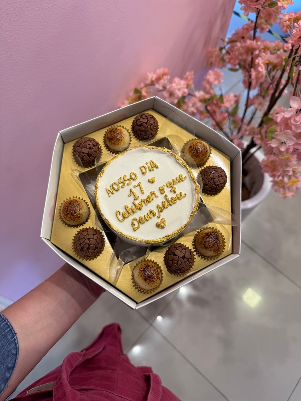 Caixa hexagonal com bentô escrito à mão e brigadeiros ao redor