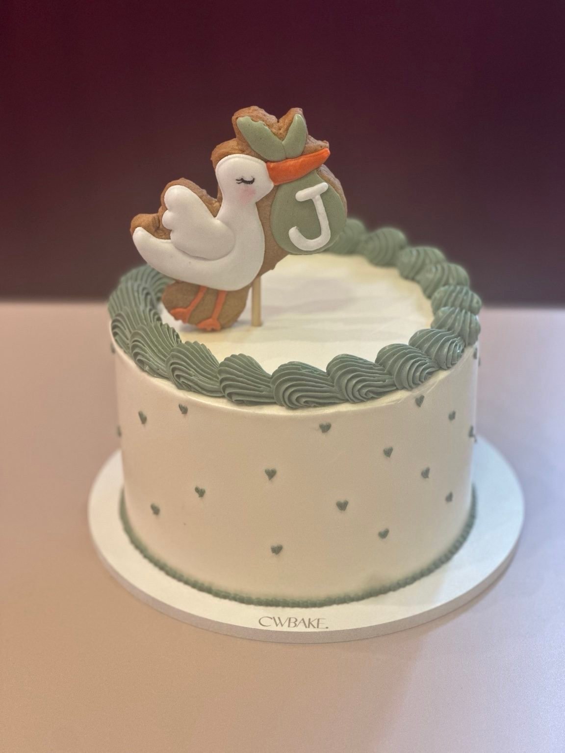 Bolo com biscoito decorado de cegonha e borda verde