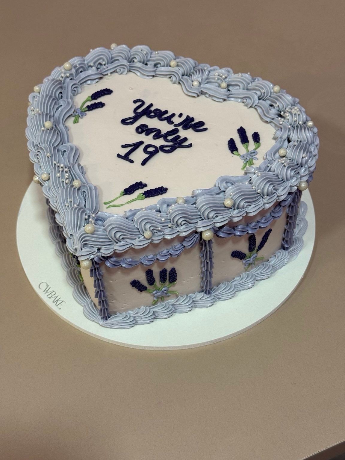 Heart cake com bordas lilases, frase escrita e raminhos de lavanda desenhados