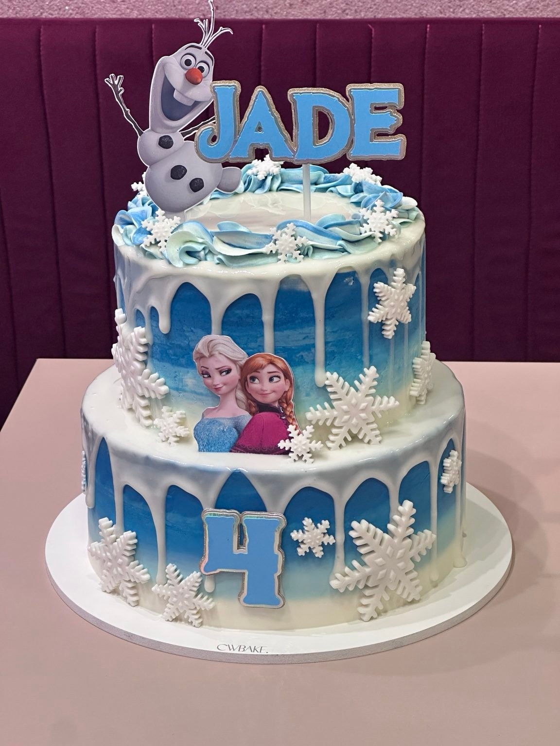 Bolo de dois andares azul e branco com tema Frozen e nome no topo