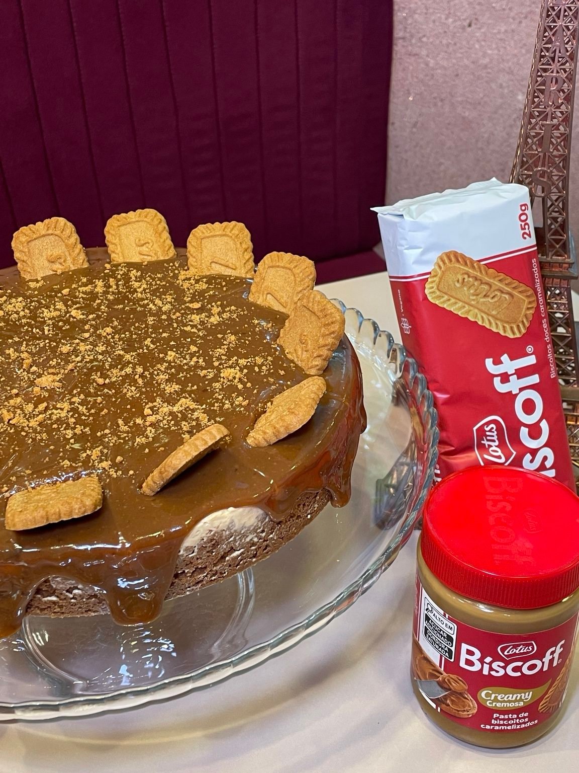 Cheesecake de Biscoff com biscoitos no topo, ao lado de embalagens de Biscoff